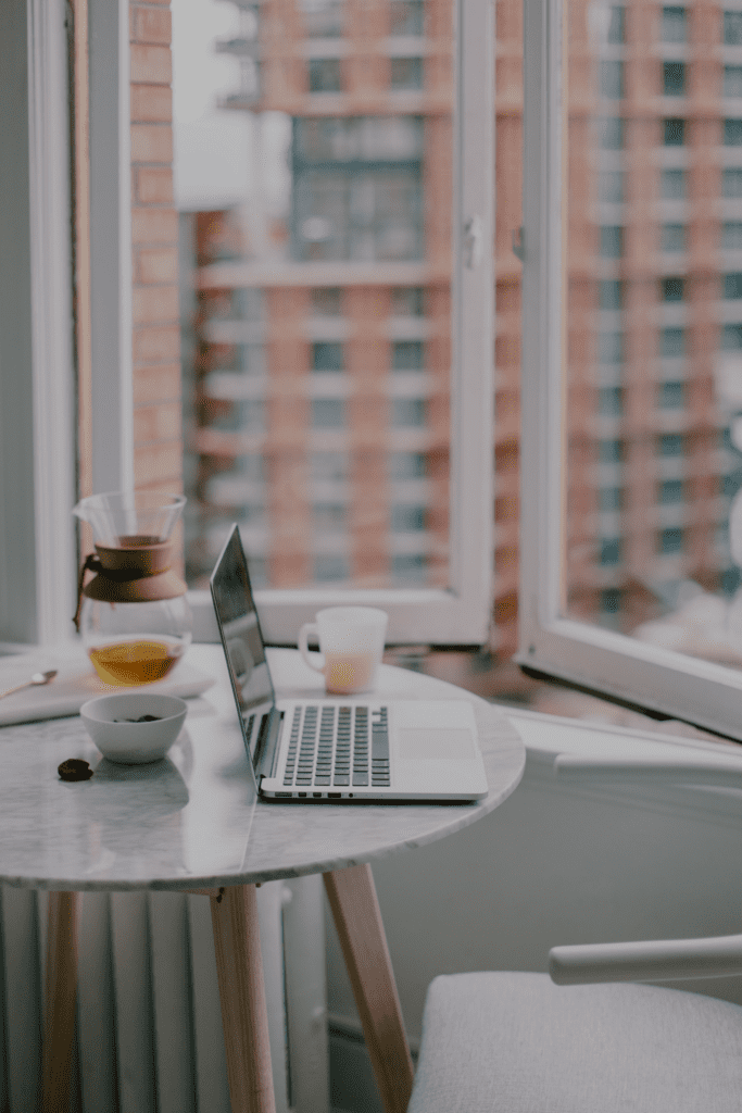 Laptop on table with apartment building in background