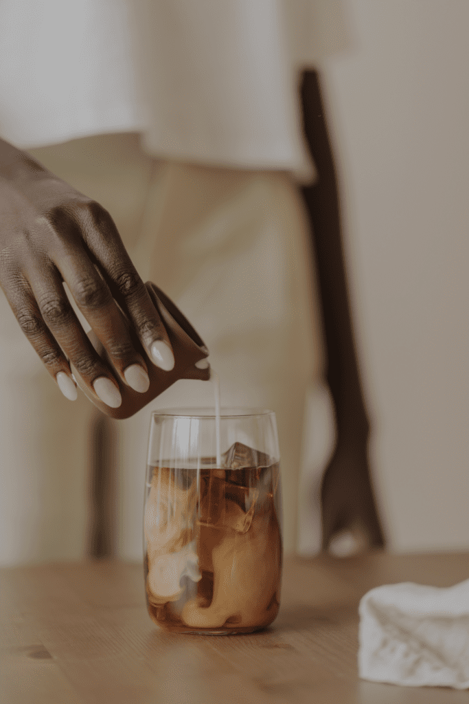 Woman pouring milk into coffee